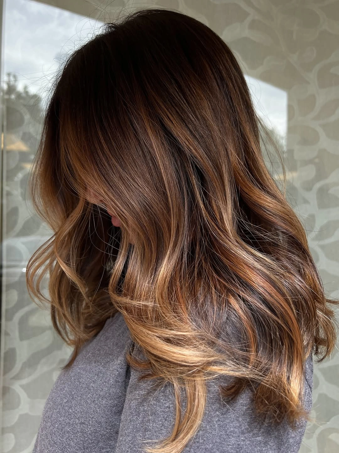 warm brown hair with caramel ends and waves