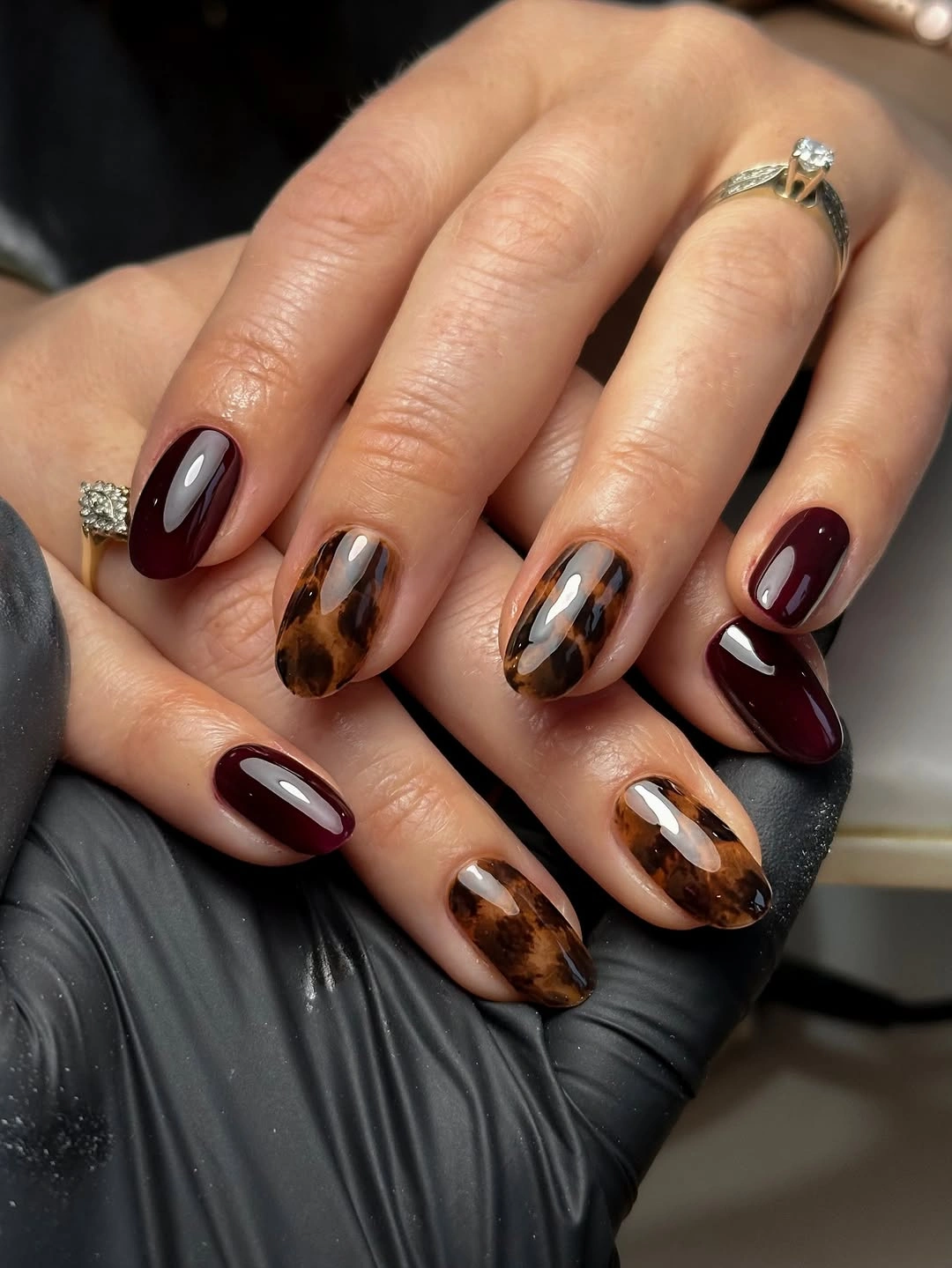 Fall nail idea: medium rounded-square burgundy and tortoiseshell manicure