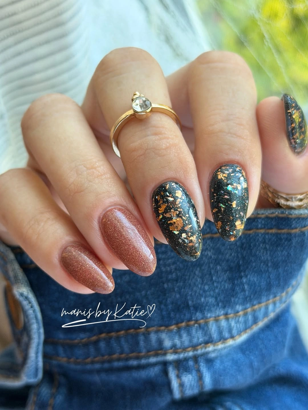Medium almond nails with dark teal glitter and warm neutrals