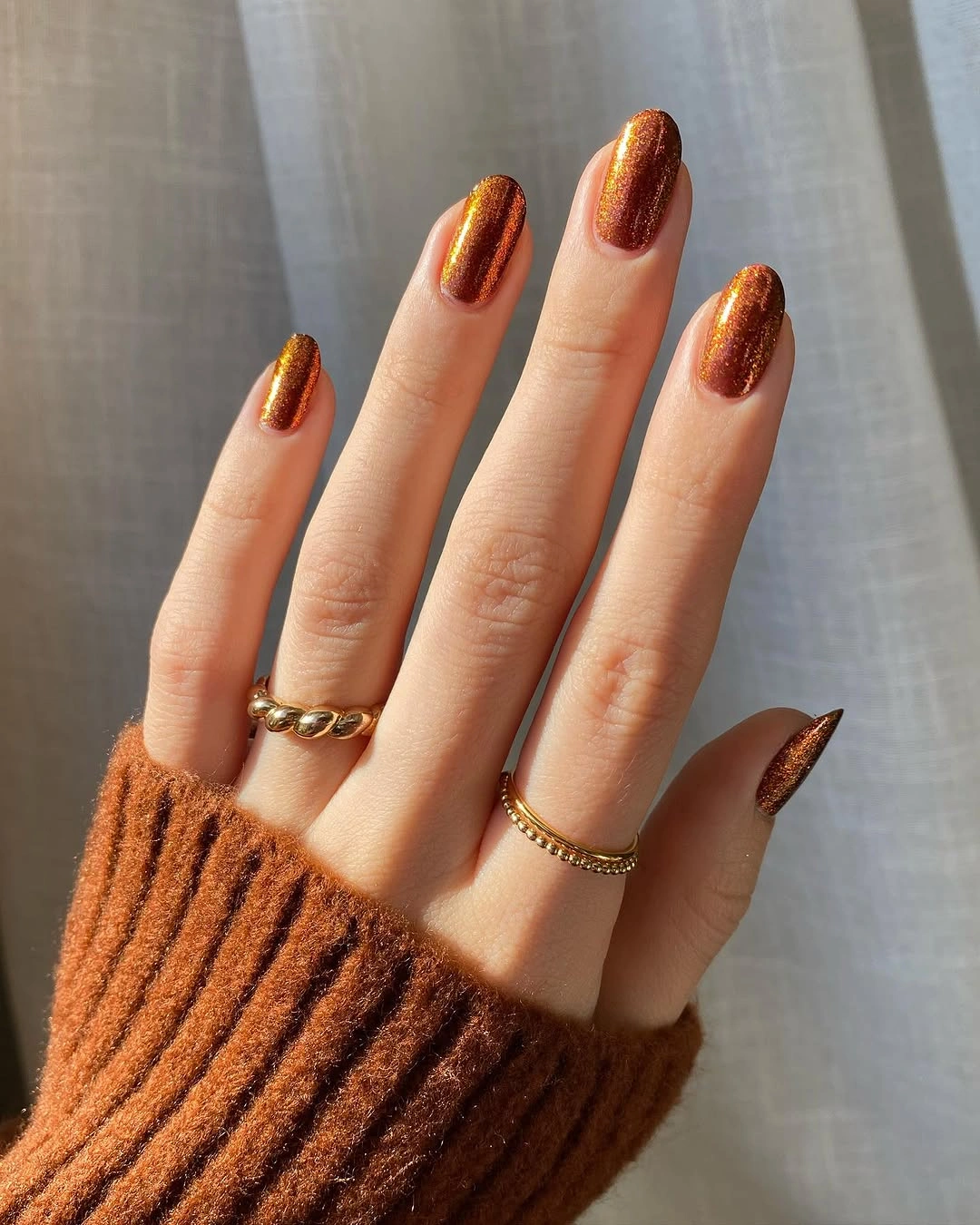 Medium almond nails in reflective copper orange