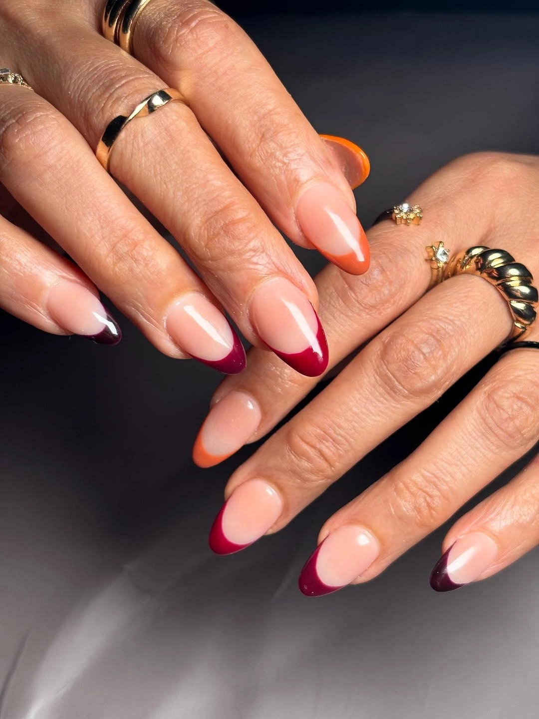 pink French nails with red and orange swirl tips