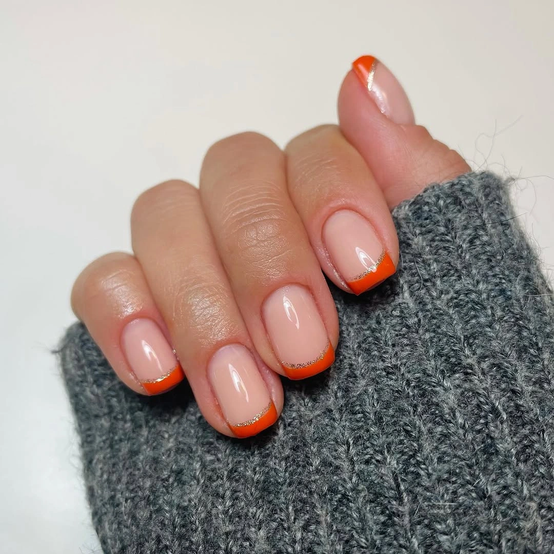 short oval nails with bright orange French tips