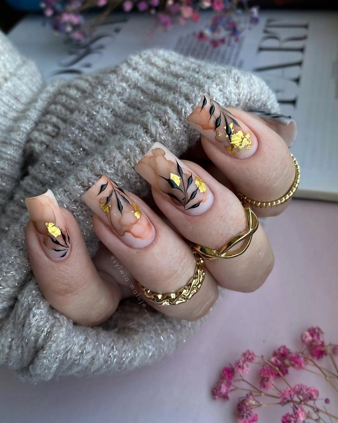 long nude almond nails with botanical lines and gold accents