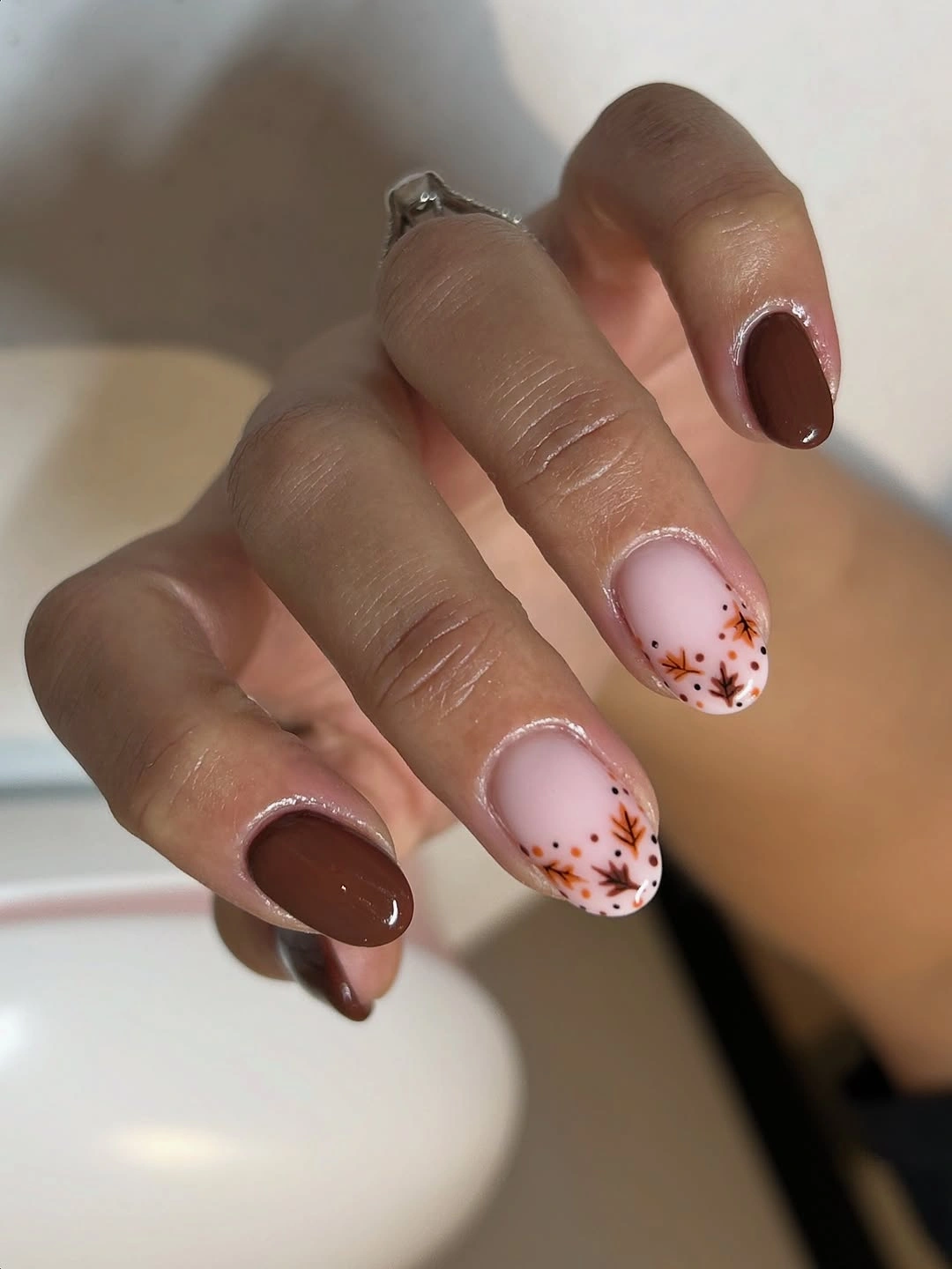 short rounded brown nails with small floral accents