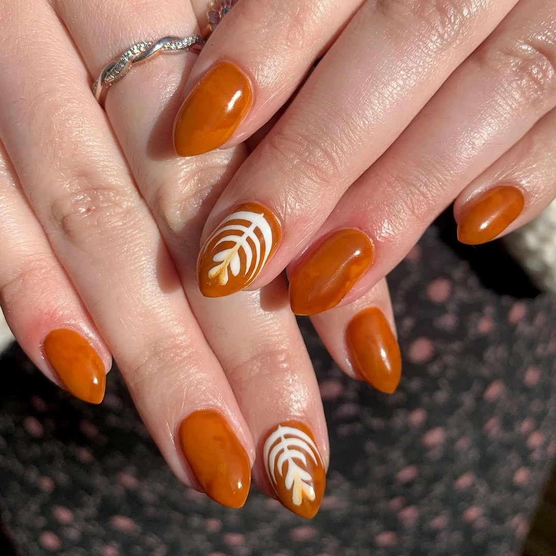 short almond amber nails with white leaf line art
