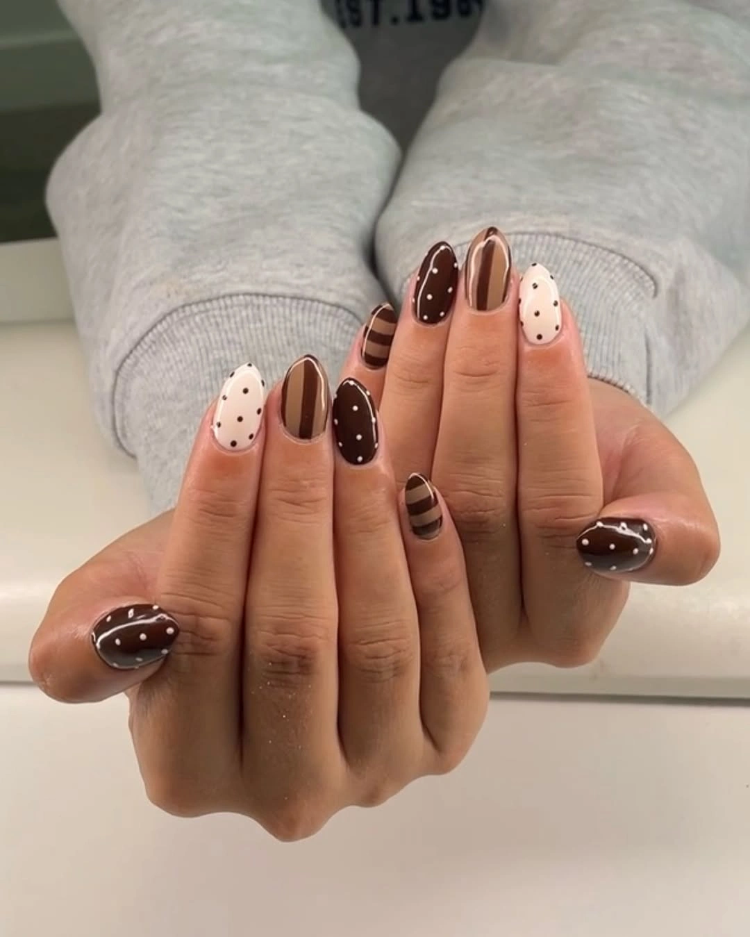 short rounded brown cream and black patterned nails