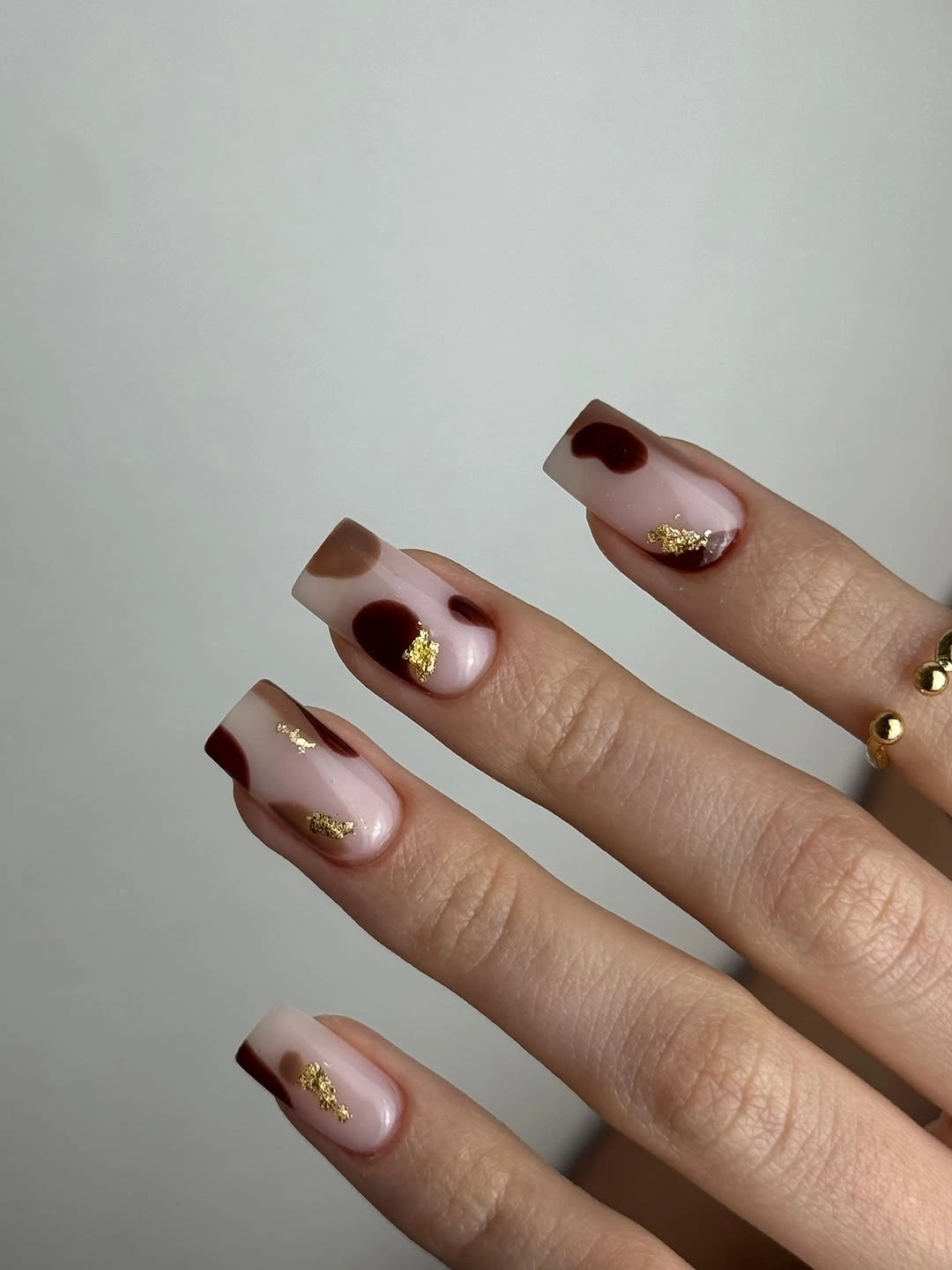 medium square nails with brown tips and gold flecks