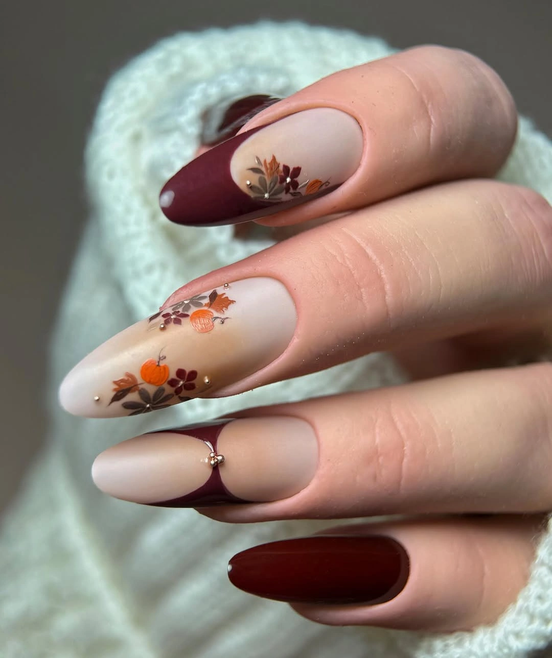 Burgundy almond nails with milky edges and tiny autumn flowers