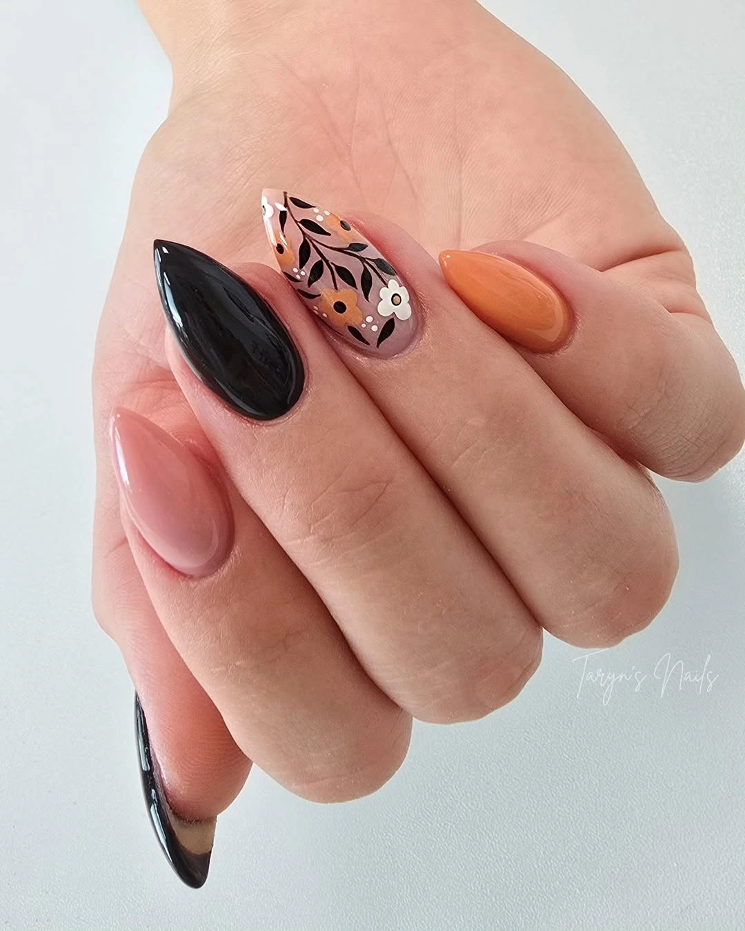 Black orange almond nails with an abstract spotted accent