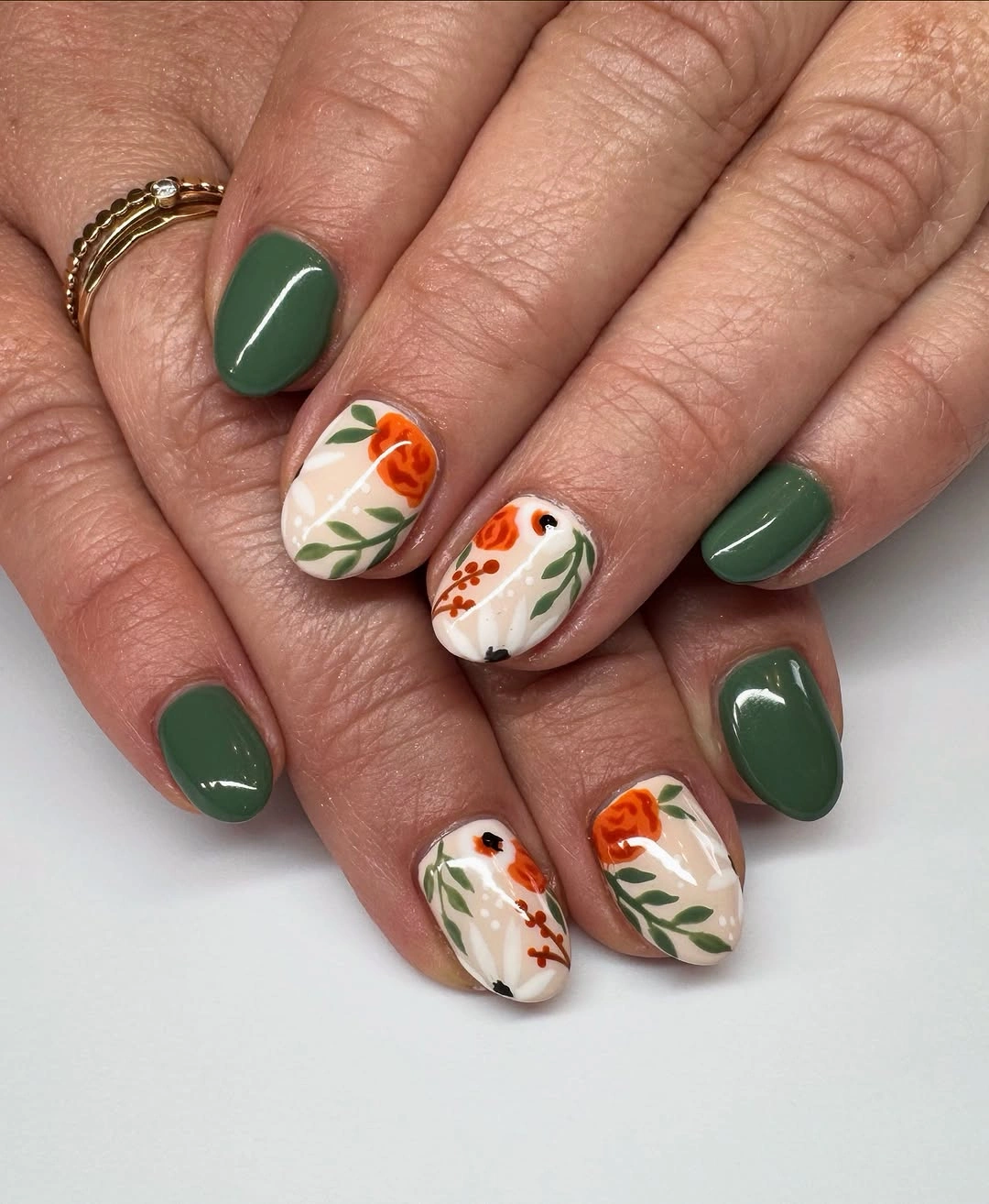 Short green nails with cream orange botanical accents