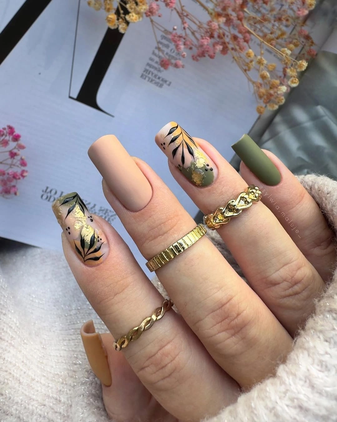 Long square nails in nude peach olive and dark accents