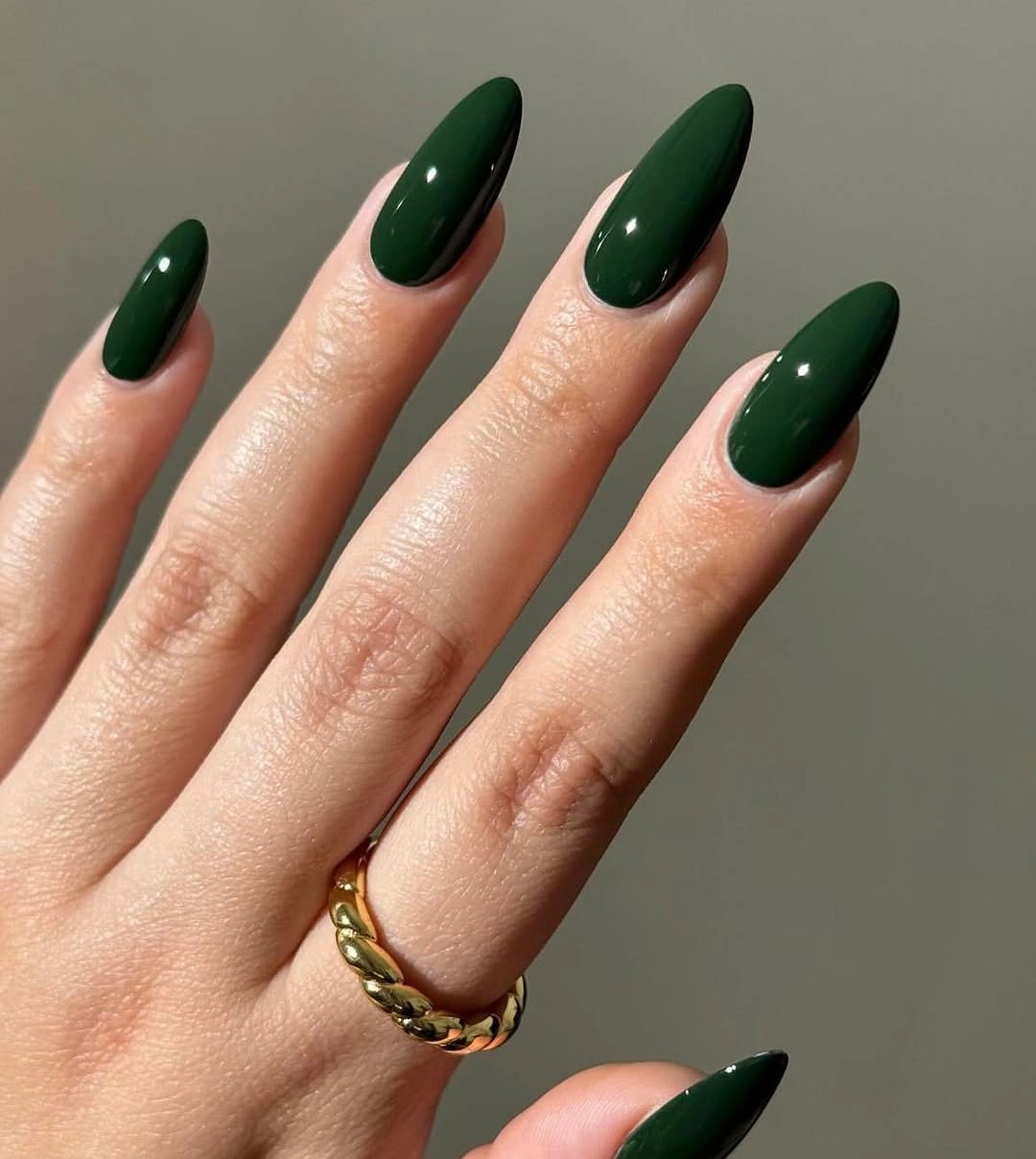 Long almond nails in glossy deep forest green