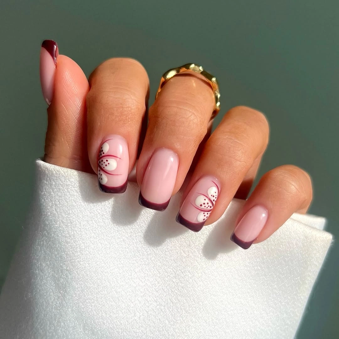short square nails with burgundy tips and dotted accents