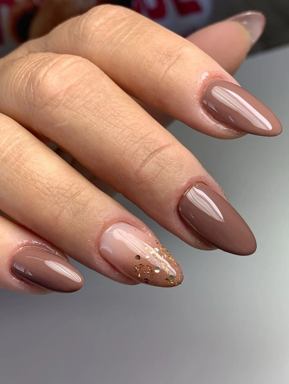 long almond nails in sheer brown with a fine gold accent