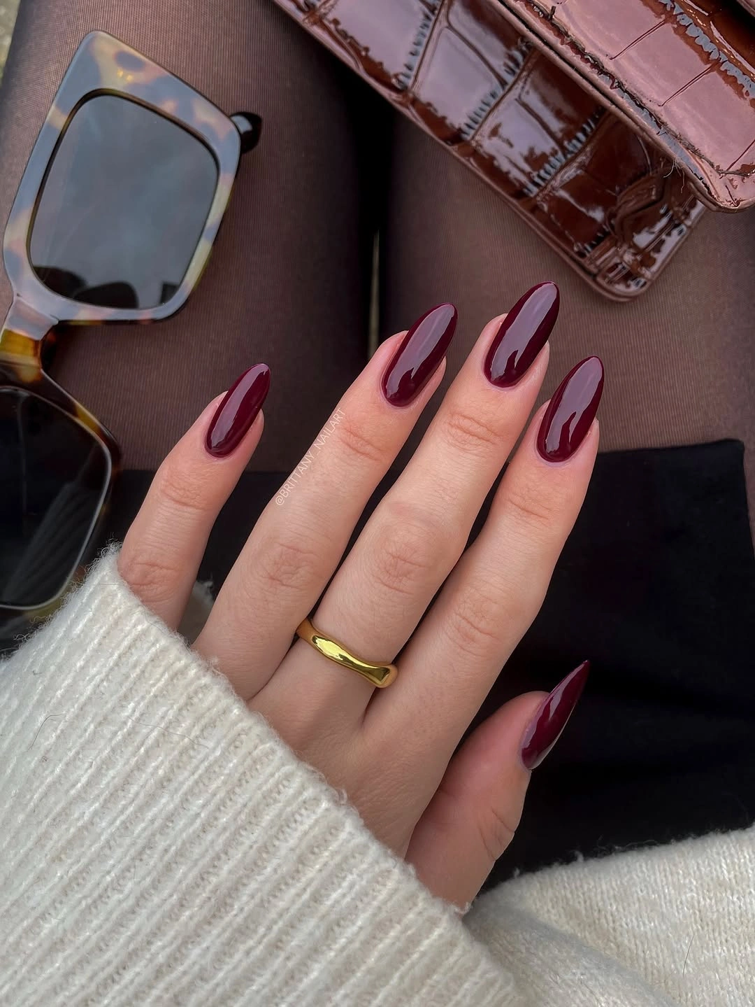 long almond nails in a glossy deep wine shade