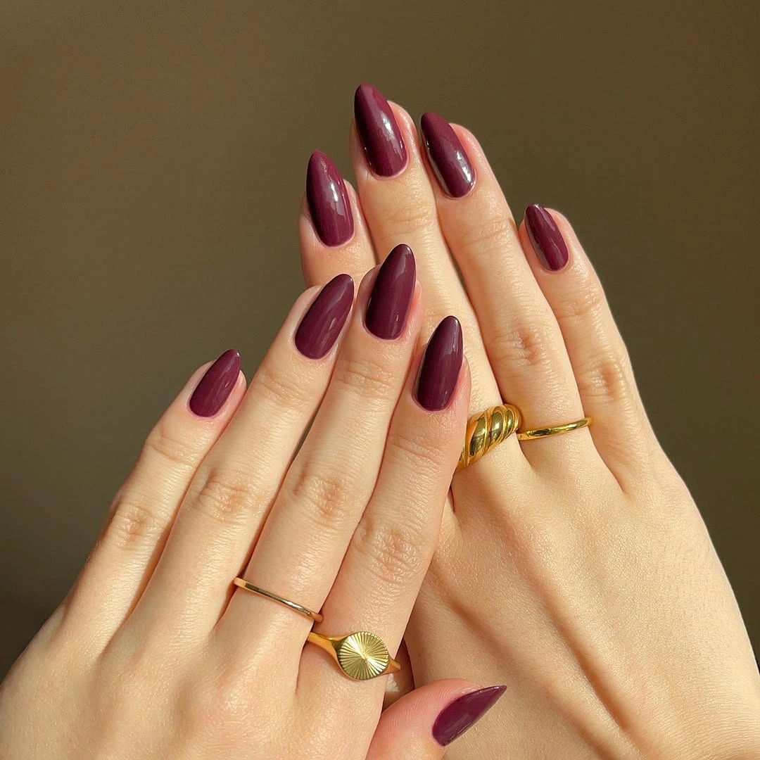 long almond nails in a deep glossy berry shade