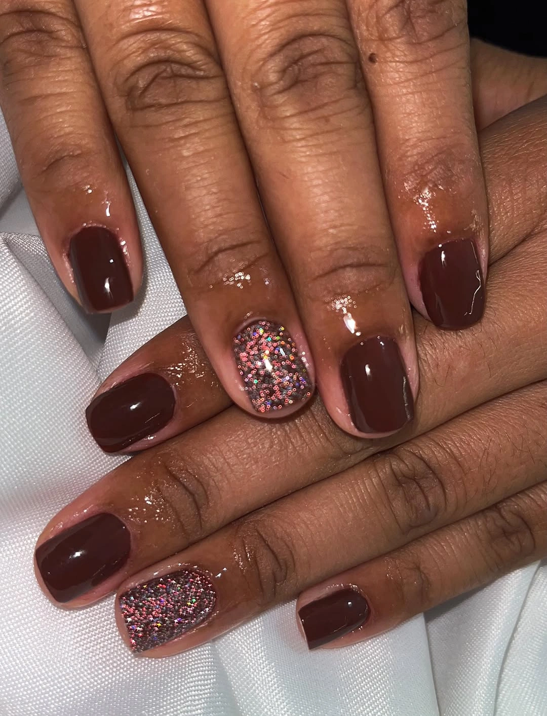 short square dark brown nails with multicolor glitter accents