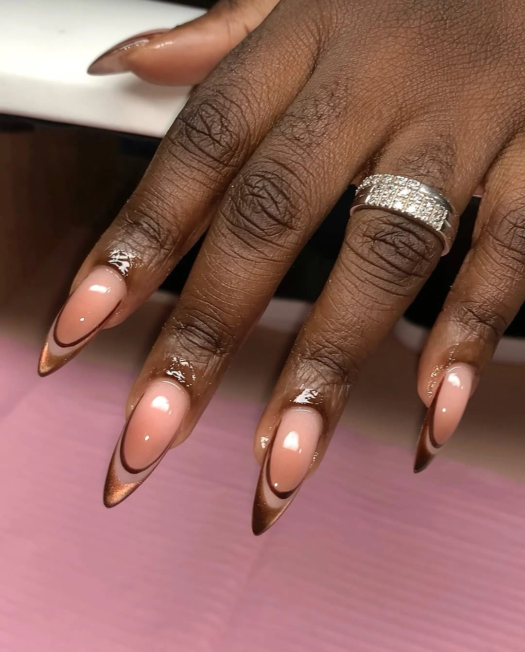 long nude almond nails with copper-brown French tips