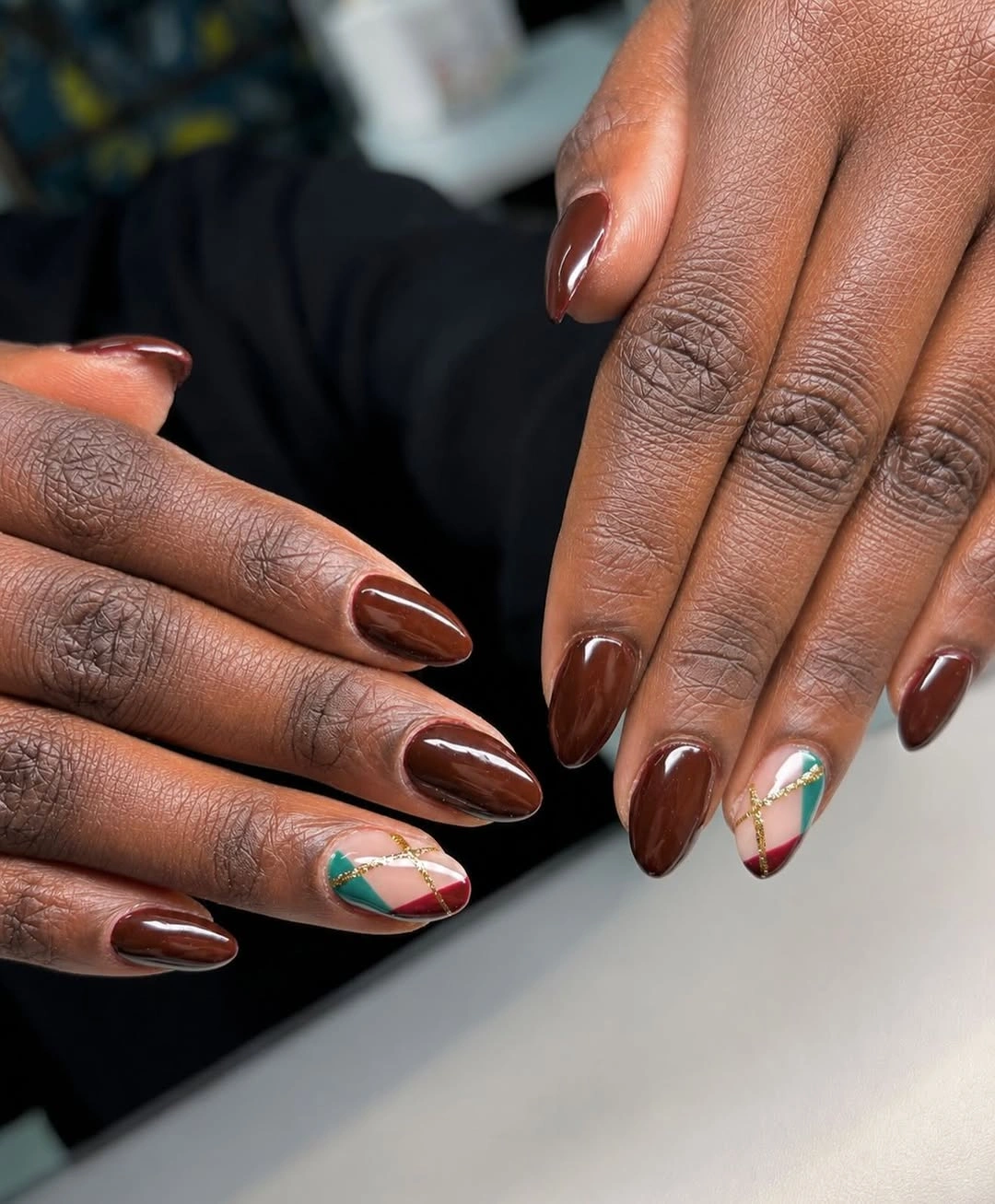 Deep brown almond nails with small colorful tip accents