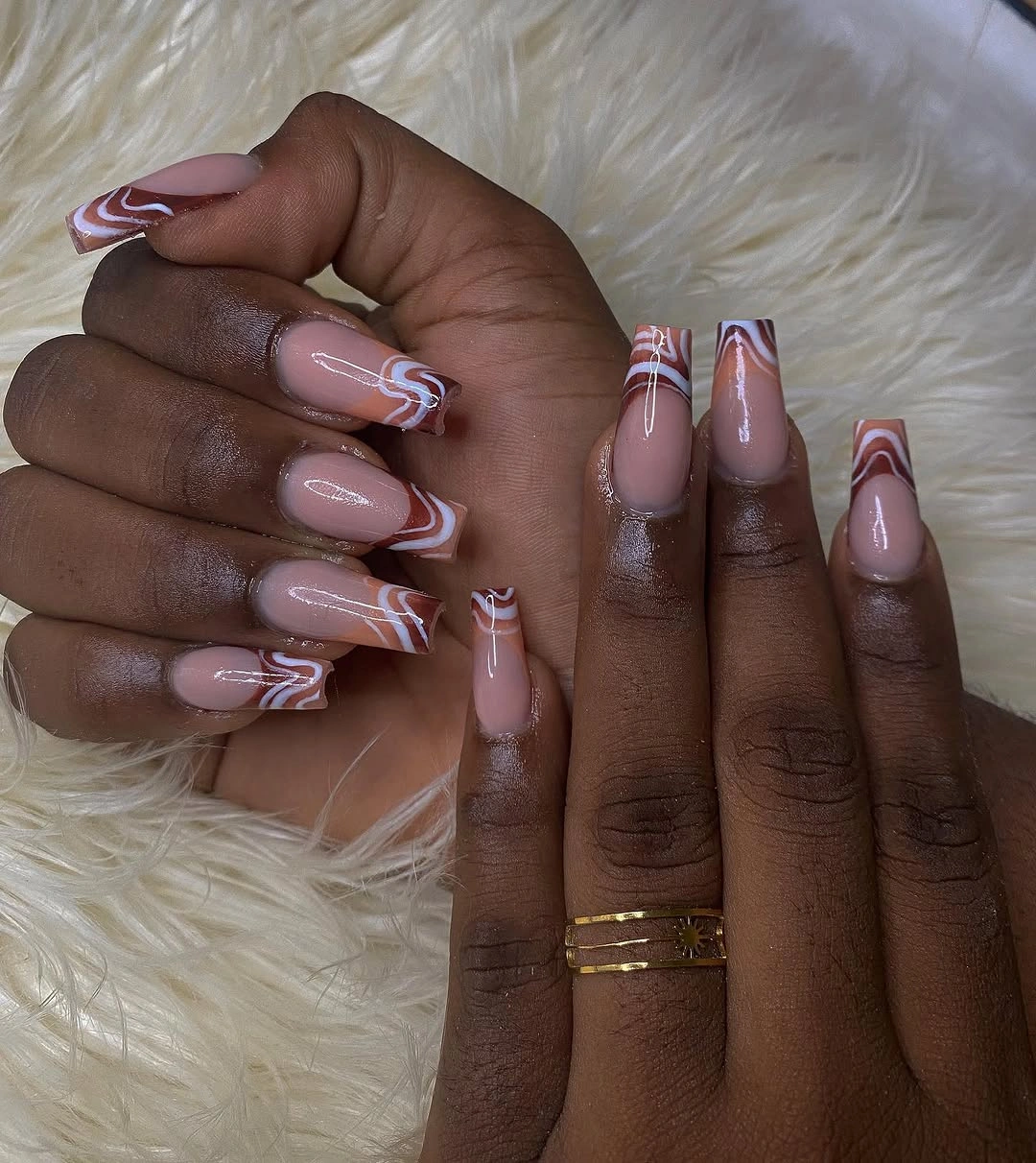Pale pink almond nails with layered warm wavy lines