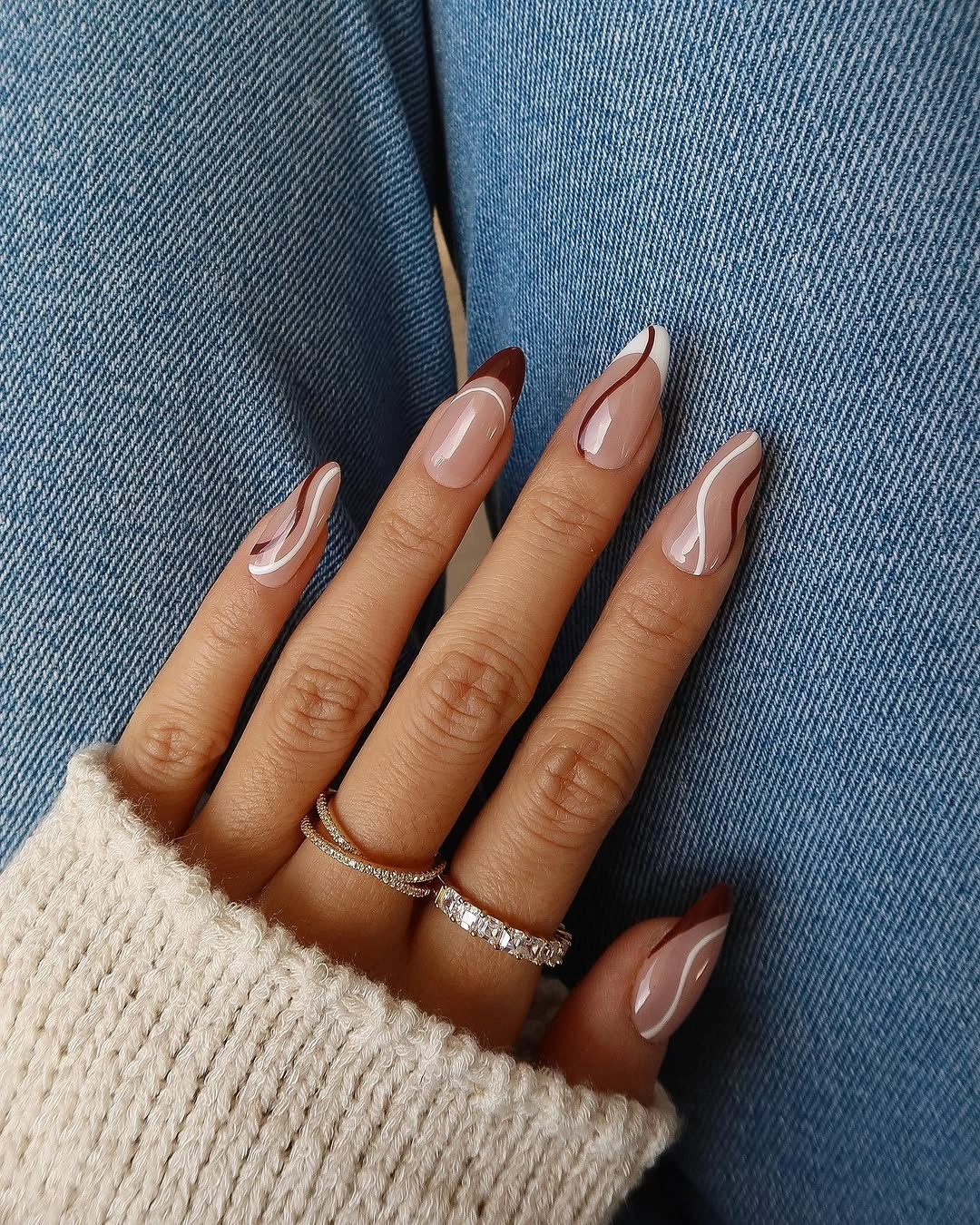 Translucent pink almond nails with chocolate brown outlines