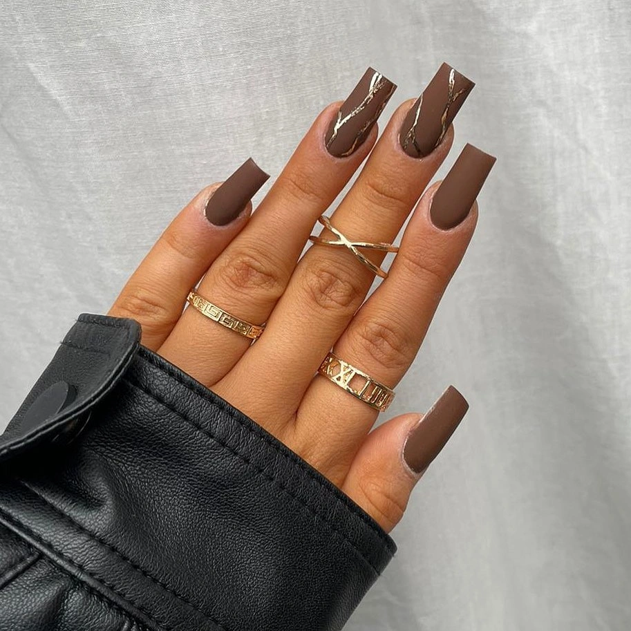 Long squared nails with nude bases and brown tips