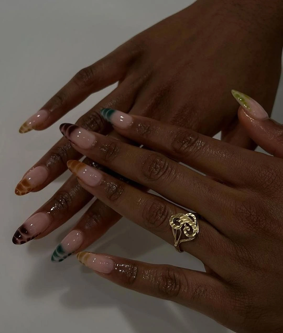 Pale almond nails with brown green and warm tip accents