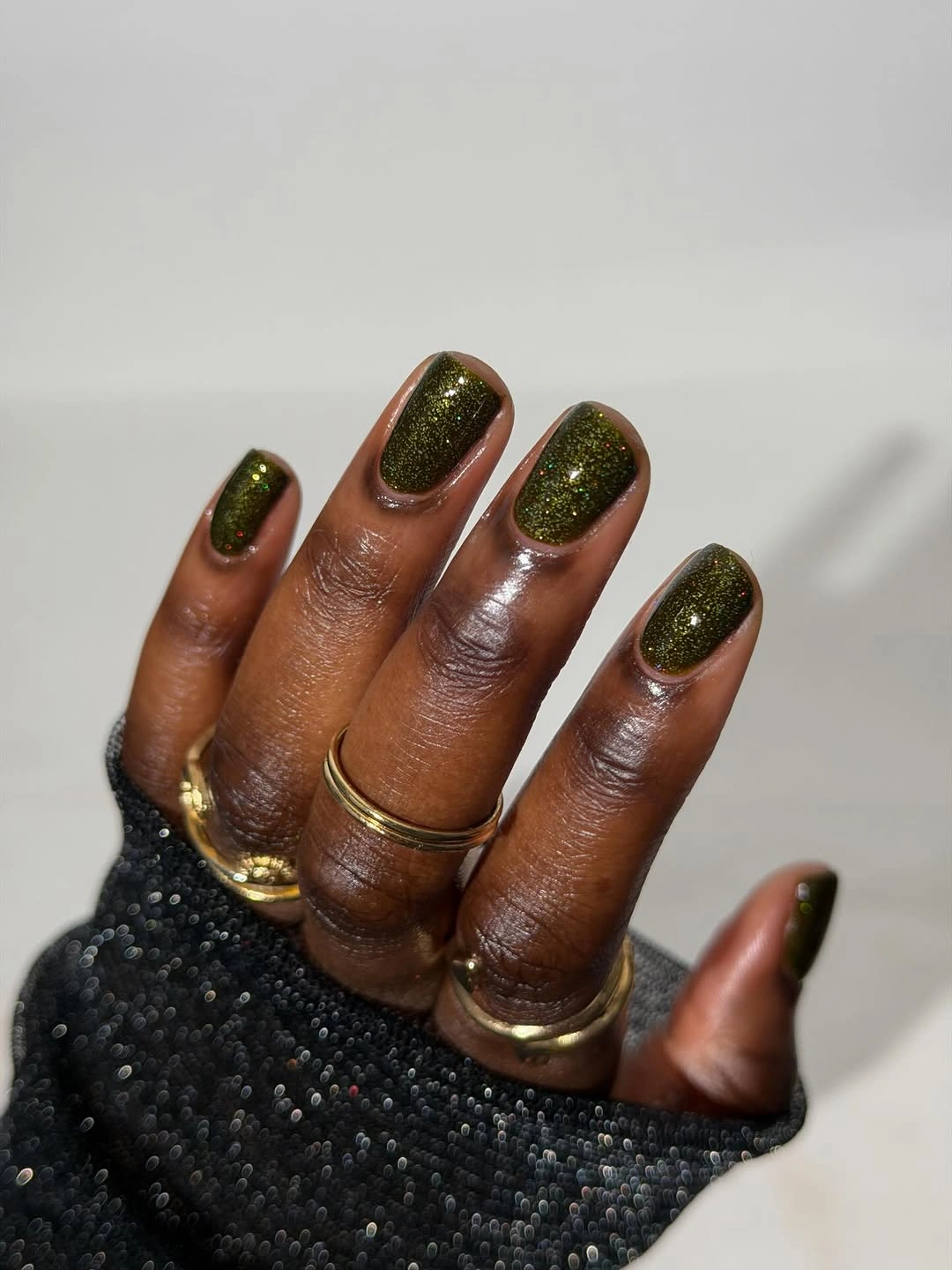 Short oval nails in dark olive with subtle shimmer