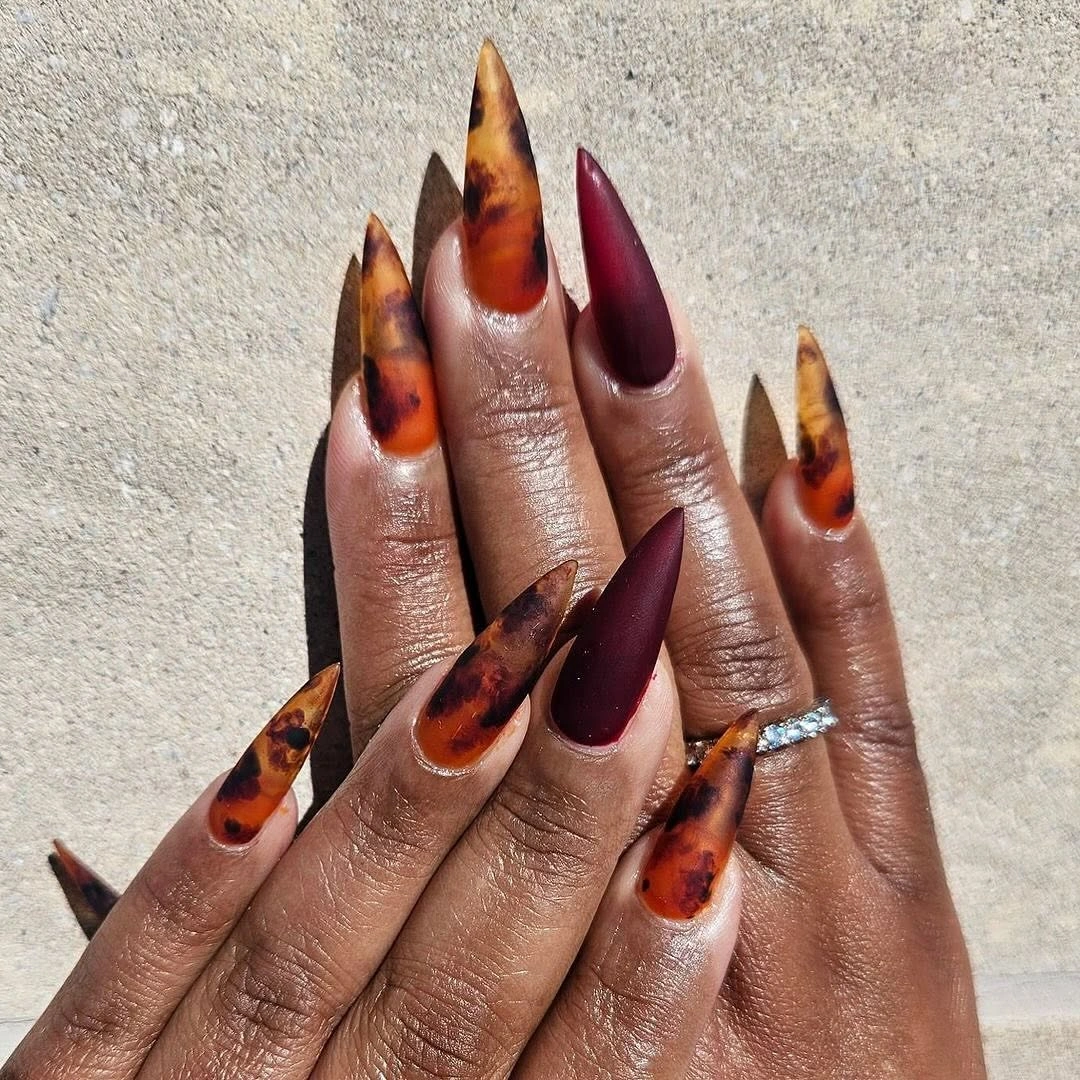 long amber burgundy nails with flame-like tips