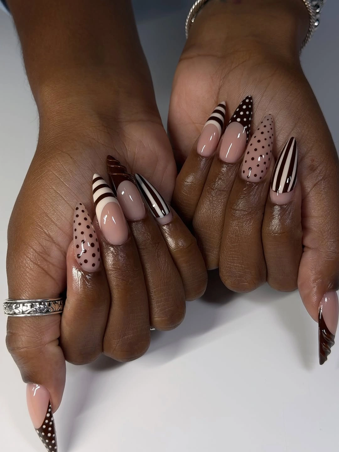blush almond nails with dots and striped accents