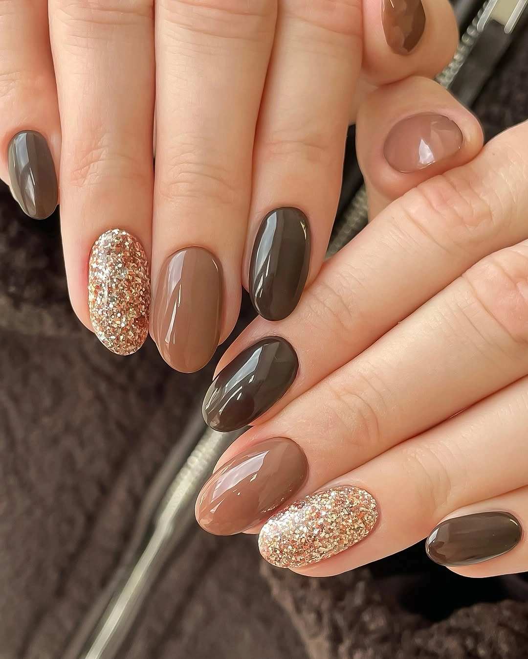 Taupe charcoal almond nails with reflective golden accents