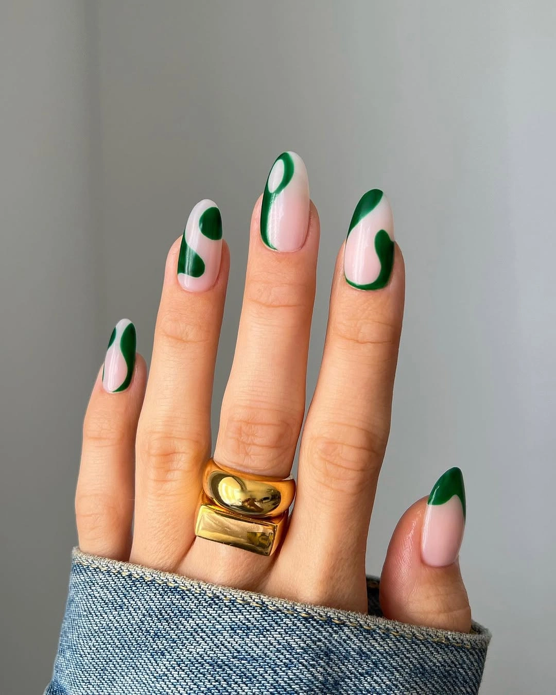 Pale pink almond nails with deep green curved edges