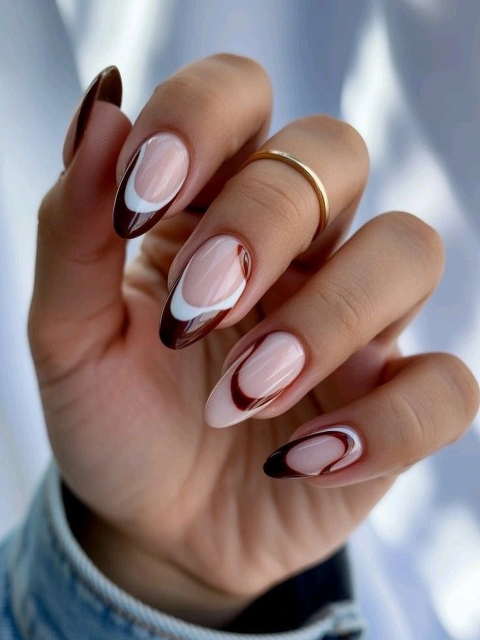 Pale almond nails with dark brown framing and accents