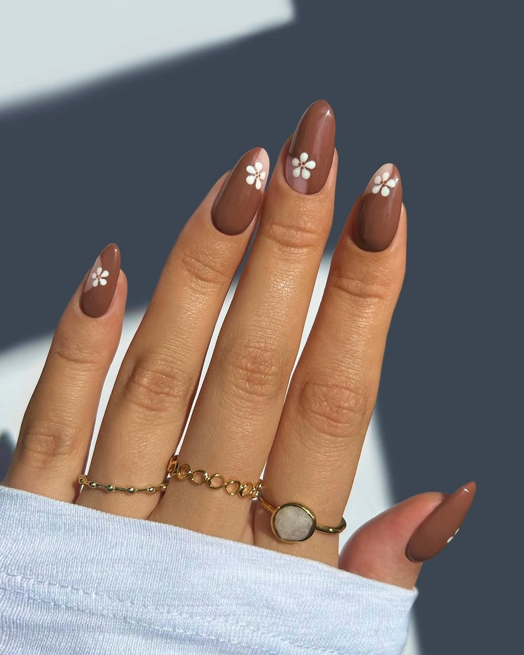 Warm brown almond nails with small pale floral accents