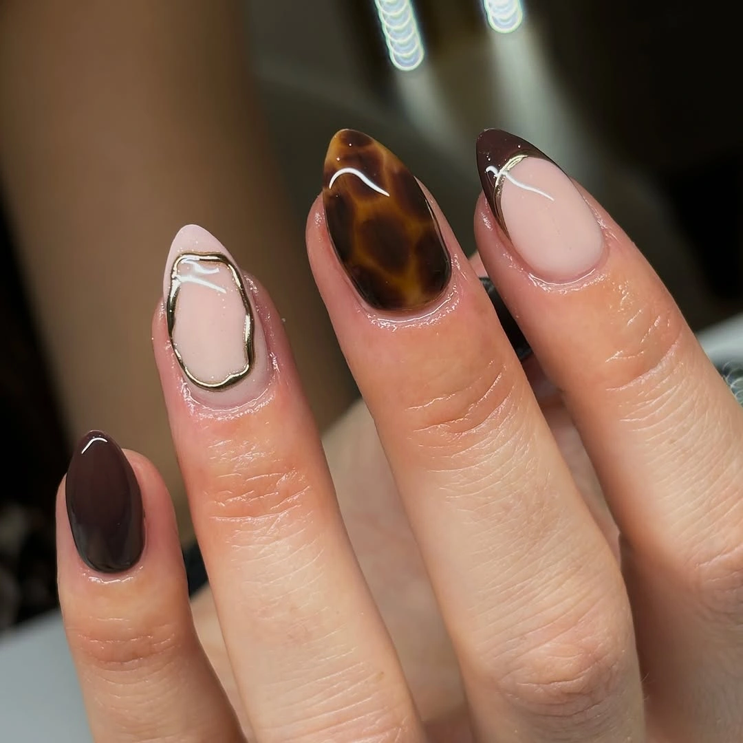 Deep brown almond nails with a translucent patterned accent