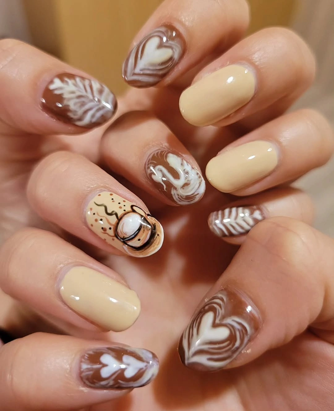 Fall nail idea: short rounded cream and brown swirled manicure