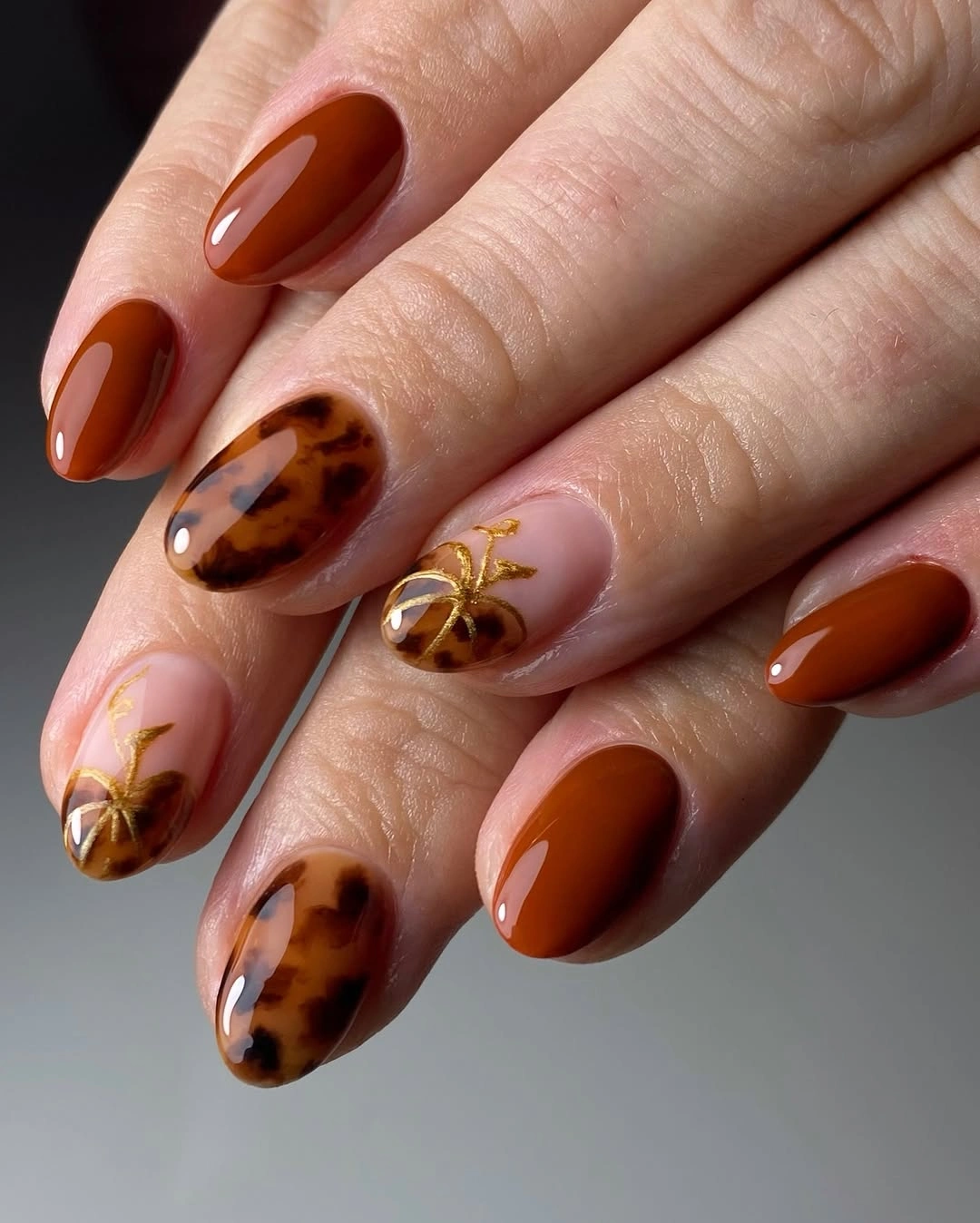 Medium almond orange brown nails with tortoiseshell and gold pumpkins