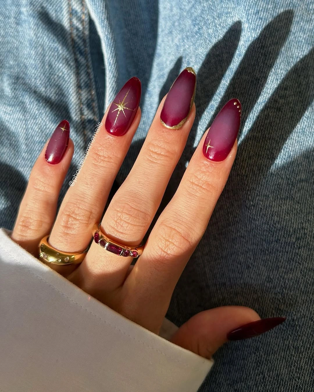 Burgundy nails with gold starbursts