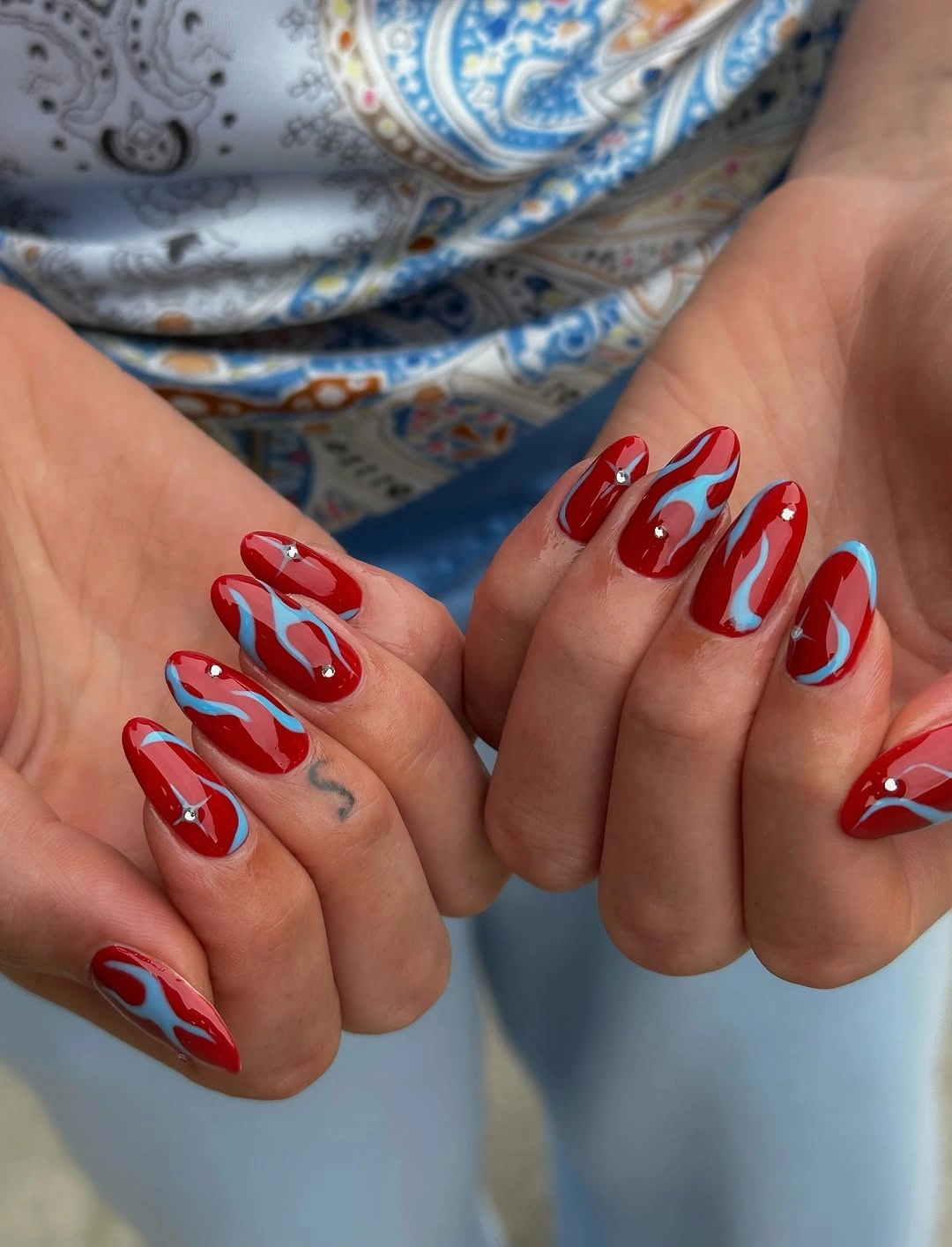 Red nails with blue metallic swirls