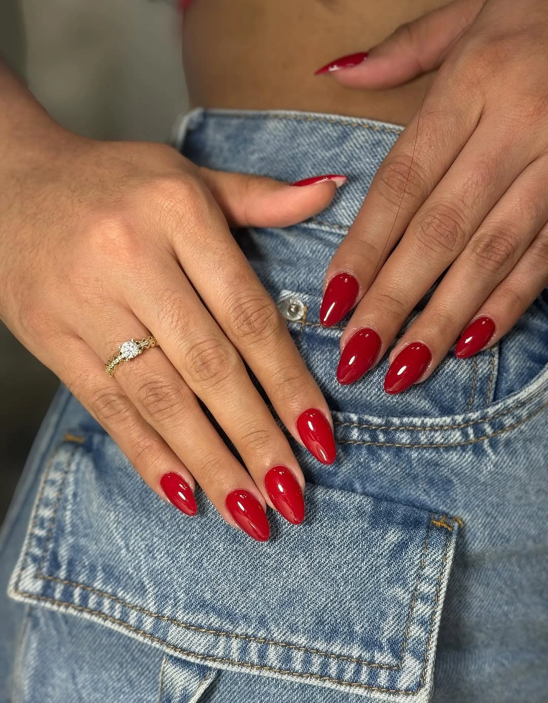 Glossy red oval nails with denim