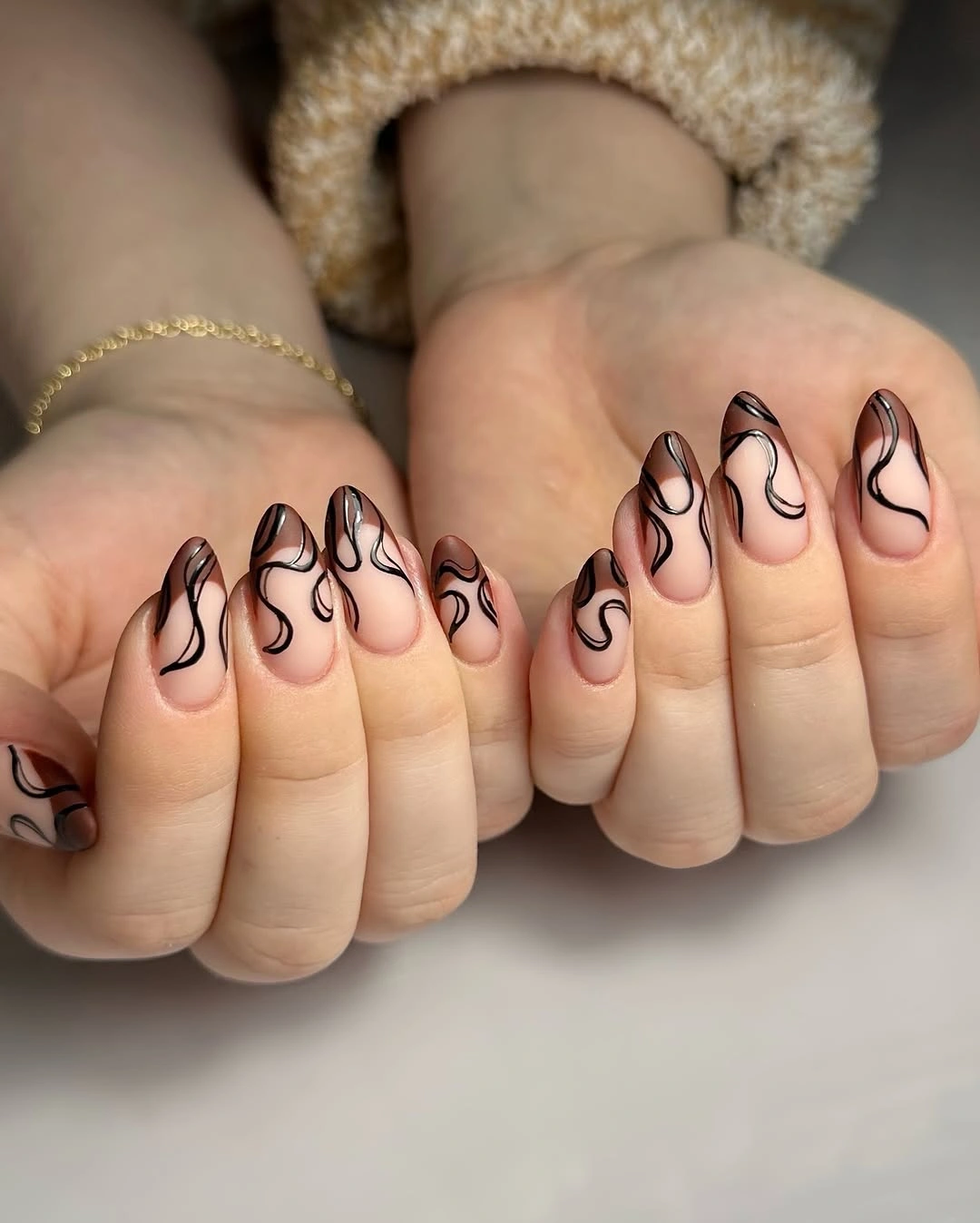 short soft brown almond nails with black abstract lines