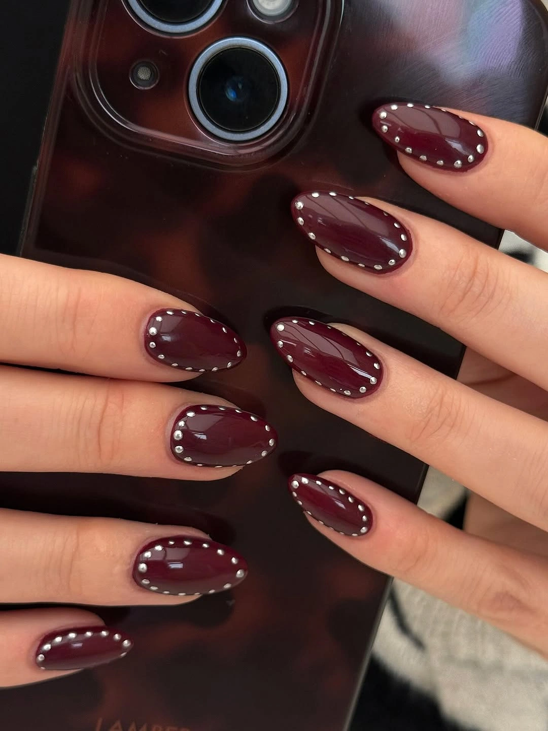 short wine almond nails with dotted outlines