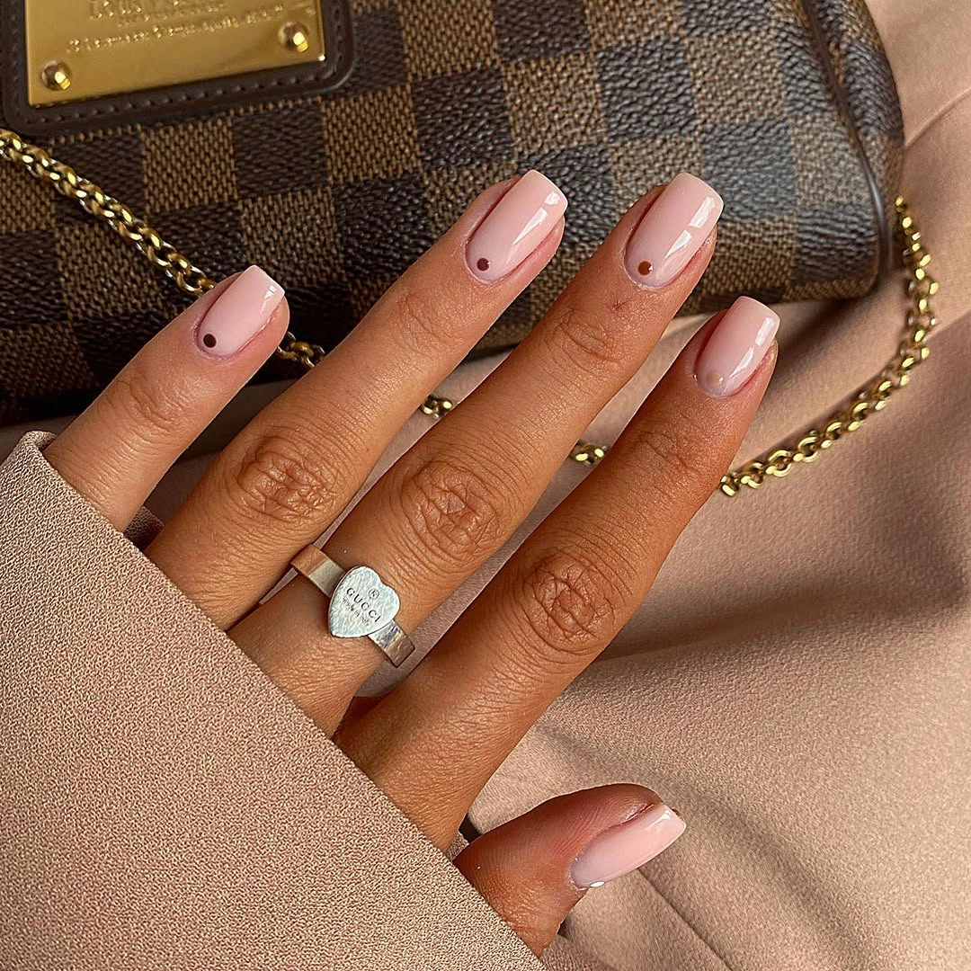 short pale pink square nails with tiny dark marks