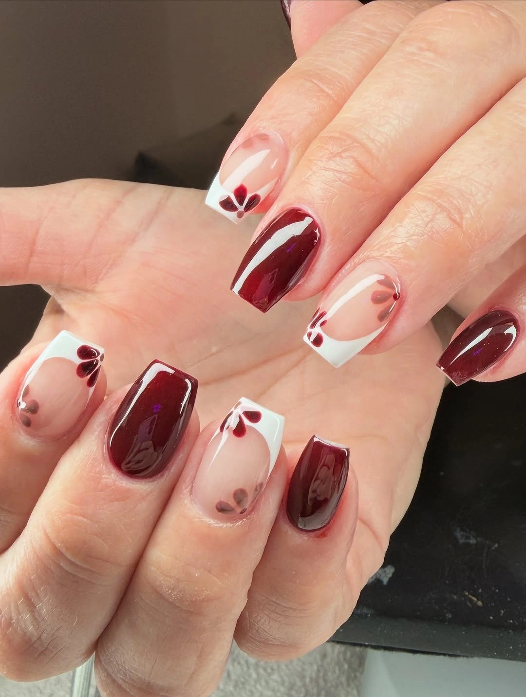short burgundy coffin nails with white edges and tiny accents