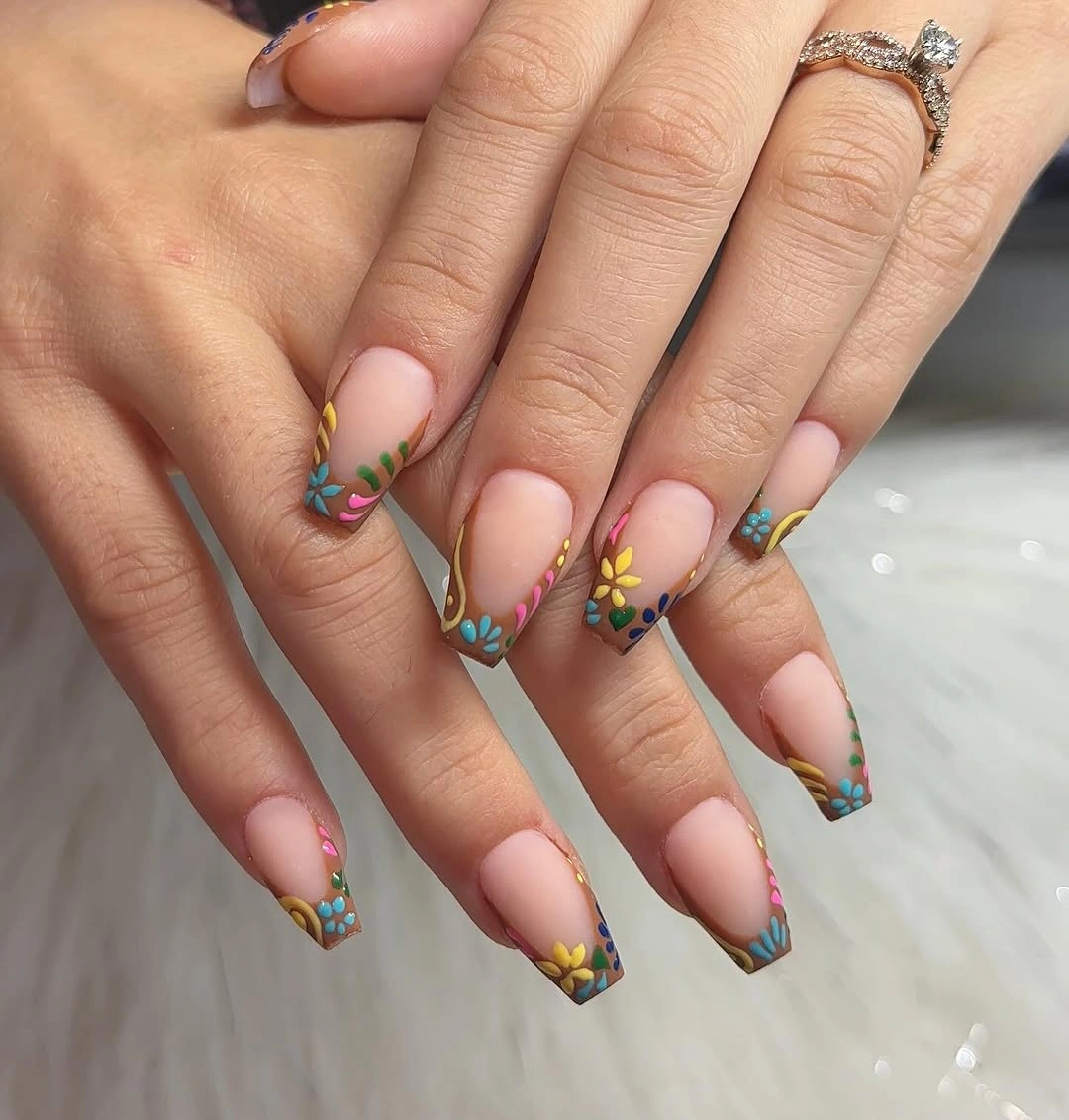 short nude coffin nails with blue tips and tiny flowers