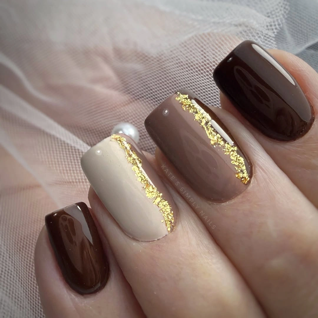 Medium square chocolate cream nails with vertical gold lines