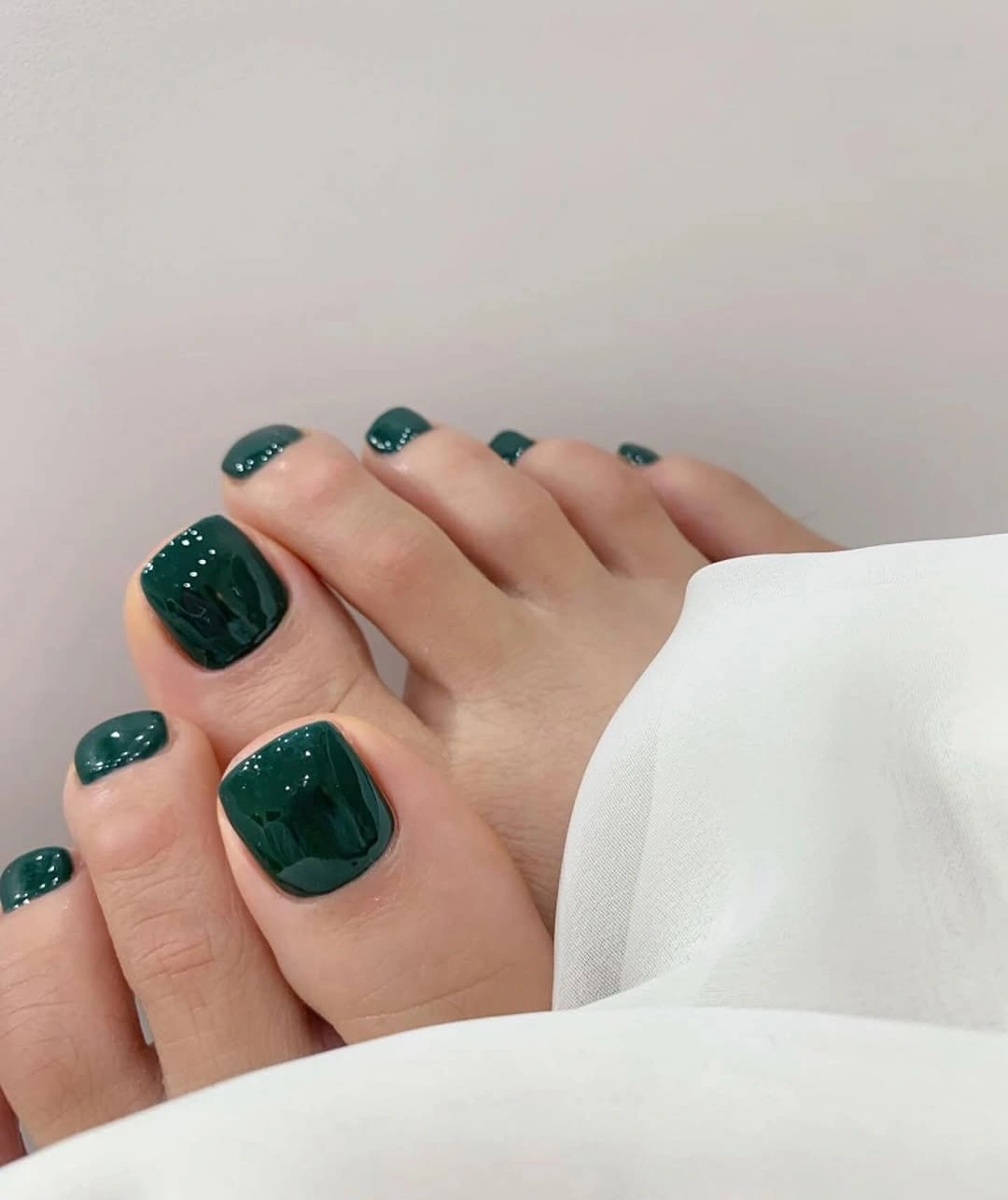 Deep forest green polish on short square toes