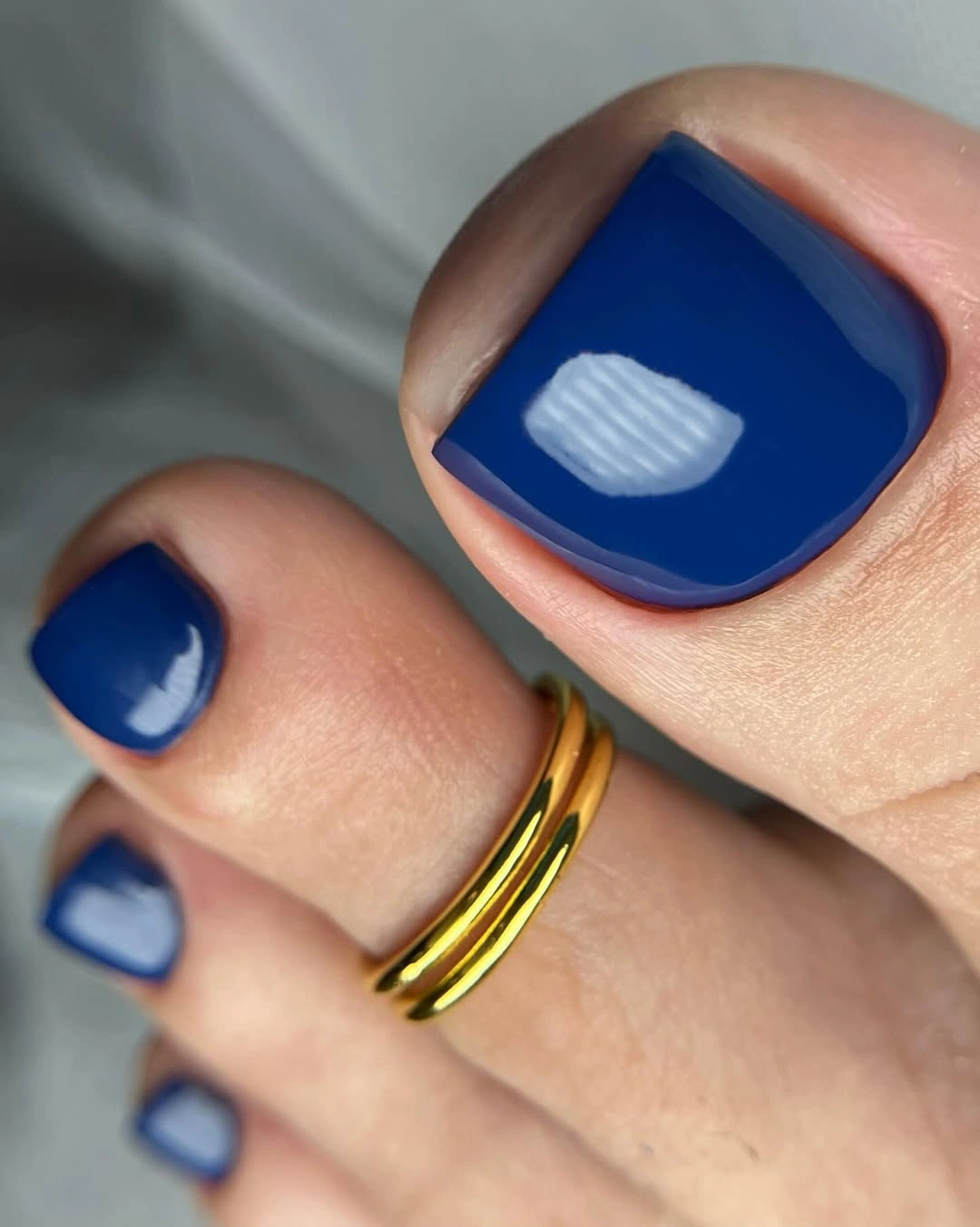 Saturated cobalt blue polish on short square toes