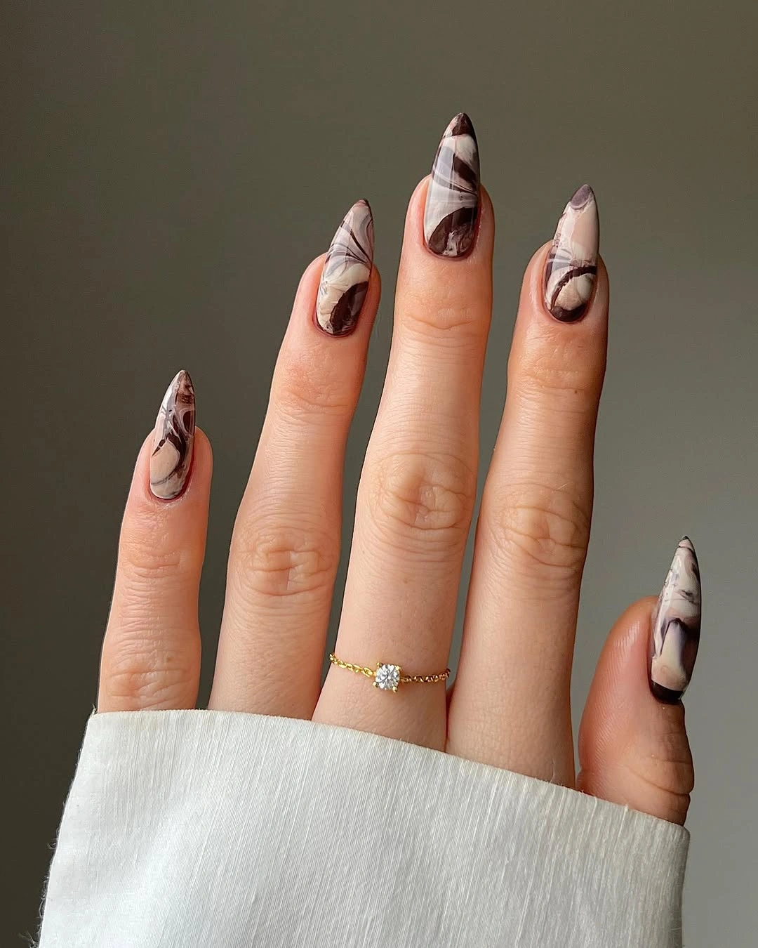 Pale almond nails with fine brown and black waves