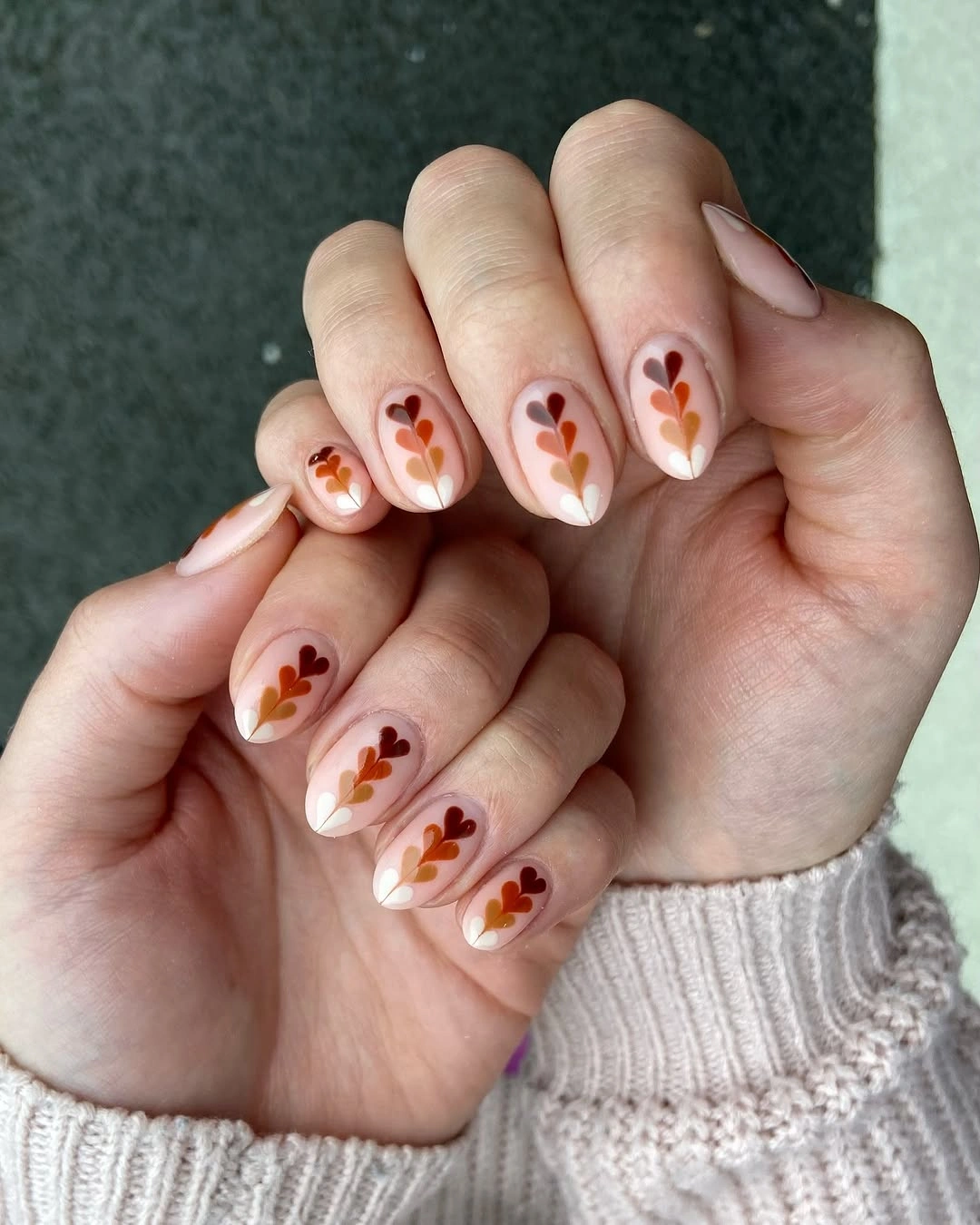 creamy pink nails with small rust flower accents